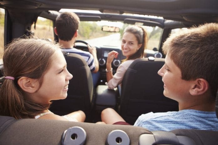Parents Taking Children On Trip In Open Top Car