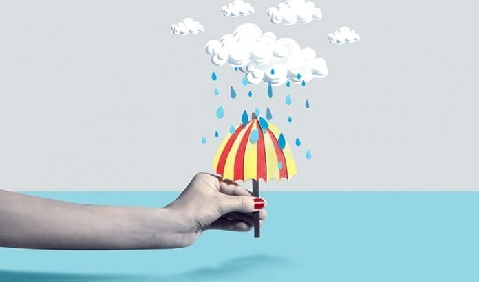 Hand-holding-umbrella-over-water