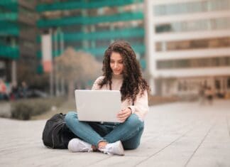 woman in pink sweater using laptop